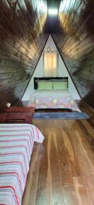 a bedroom with a bed in a wooden attic at Chalé Paraíso das Nascentes in Salesópolis +44 photos
