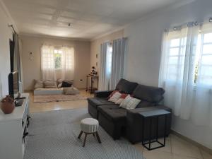 a living room with a couch and a tv at Kascata Complexo de Refúgio in Conceição dos Ouros