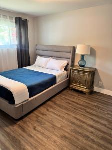 a bedroom with a bed and a night stand with a lamp at Luxe Living Prime Location in Kitchener