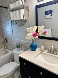 a bathroom with a sink and a toilet and a mirror at Luxe Living Prime Location in Kitchener