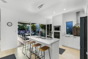 a kitchen with a white counter and stools at The Palms in Perth