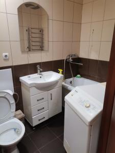 a bathroom with a sink and a toilet and a tub at Затишна квартира in Umanʼ