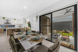 una sala da pranzo e una cucina con tavolo e sedie di Austral 5 bedroom, 2 storey detached house a Austral