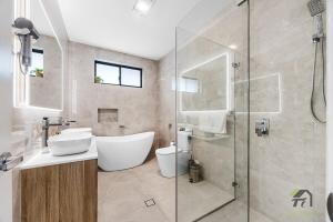 un bagno con vasca, lavandino e doccia di Austral 5 bedroom, 2 storey detached house a Austral Altre 20 foto