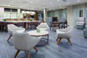 a waiting room with chairs and a table and a dining room at Courtyard by Marriott St. Louis West County in Saint Louis