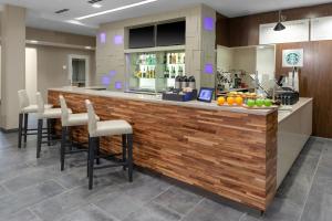 a lobby with a bar with chairs and fruit on the counter at Courtyard by Marriott St. Louis West County in Saint Louis
