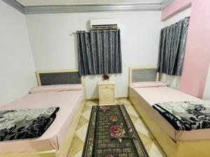 a room with two beds and a table in it at Dar Alsalam Suites in Siwa