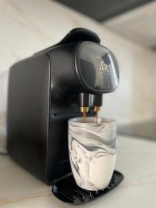 a coffee maker is making a cup of coffee at Appartement Premium - Le Trente in Dijon