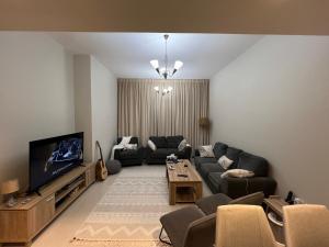 a living room with a couch and a tv at Hotel apartment in Sharjah