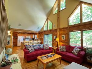a living room with two red couches and a table at Top of the Line Asheville Mountain Cabin in Leicester