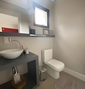a bathroom with a white toilet and a sink at Casa Dani · CURTA! |143| Aconchegante Casa 3 suíte in Joinville