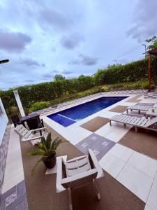a pool with chaise lounge chairs and a swimming pool at Casa quinta Aluna in Carmen de Apicalá