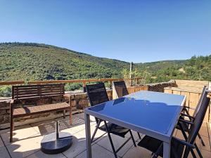 a blue table and chairs on a patio with a bench at Oleandre in Cassagnolles