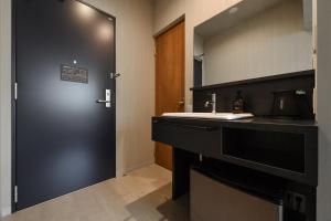 a bathroom with a black door and a sink at Hotel Yatsu in Komatsu +14 photos