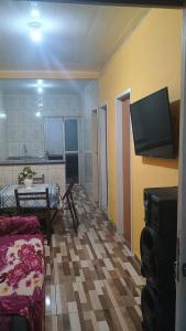 a living room with a couch and a flat screen tv at Pensão da tia Léia in Belém