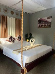two beds in a bedroom with a rope swing at The Bangka Beach Guesthouse in Siquijor +23 photos