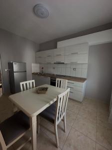 eine Küche mit Tisch und Stühlen und einem Kühlschrank in der Unterkunft S&E apartments in Tirana