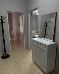 ein Bad mit einem Waschtisch mit einem Spiegel und einem Spiegel in der Unterkunft S&E apartments in Tirana