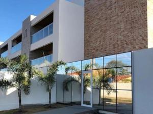 a building with glass windows and palm trees in front of it at varandasdofrancesapt216 Praia do Frances in Praia do Frances