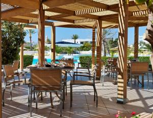 une terrasse avec des tables et des chaises ainsi qu'une piscine dans l'établissement Vincci Saphir Palace & Spa, à Hammamet