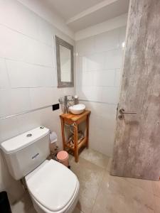 a bathroom with a white toilet and a sink at Departamento con Jacuzzi en Pinamar Centro in Pinamar