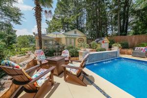a swimming pool with chairs and a table and a house at Paradise Oasis in Duluth