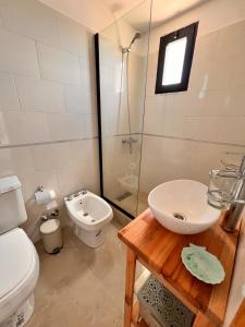 a bathroom with a toilet and a sink and a shower at Departamento con Jacuzzi en Pinamar Centro in Pinamar +55 photos
