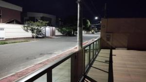 an empty street at night with a pole on a fence at Pousada Paraiso - Predio N 124 in Guarapari +1 photo