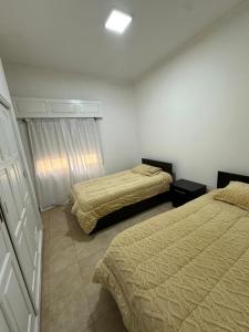 a bedroom with two beds and a window at Departamento en Microcentro in Resistencia