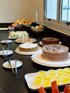 a table with cakes and other desserts on it at Hotel Salute Brasília l SLEEP HOTÉIS in Taguatinga
