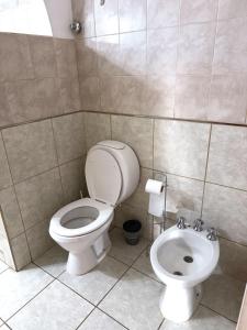a bathroom with a toilet and a sink at Departamento temporal Mariano in Santa Rosa +6 photos