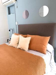 a bed with orange and white pillows on it at Departamento temporal Mariano in Santa Rosa