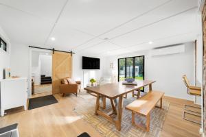 a living room with a wooden table and a dining room at The Dingaling - Beach House Bliss with Firepit & BBQ in Aldinga Beach