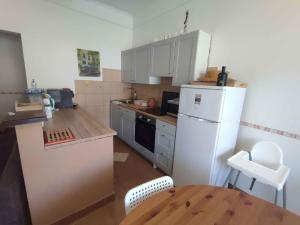 a kitchen with a white refrigerator and a wooden table at Holiday home in Balatonboglar 38776 in Balatonboglár