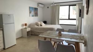 a small room with a bed and a table and chairs at Aire de Mar Alojamiento Necochea in Necochea