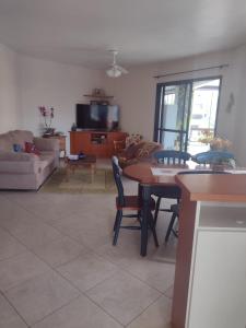 a living room with a table and chairs and a couch at Apartamento à uma quadra da praia in Torres
