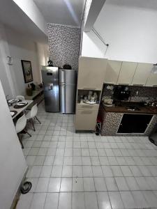 a kitchen with a refrigerator and a table at Farol da Barra express - suítes in Salvador +13 photos