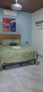 a bedroom with a bed with a painting on the wall at Loft en surf city in Tamanique +13 photos