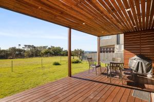 a wooden deck with a table and chairs on it at Anmere Cottage in Ventnor