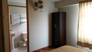 a bedroom with a black dresser and a bathroom at Antares Inn in Lima