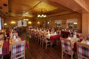 um restaurante com mesas e cadeiras num quarto em Hotel Rustika em Lermoos