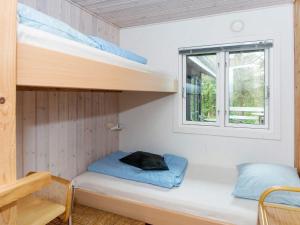 a small bedroom with bunk beds and a window at 6 person holiday home in Knebel-By Traum in Knebel