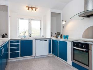a white and blue kitchen with blue cabinets at 8 person holiday home in Nordborg-By Traum in Nordborg +29 photos