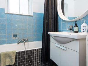 a bathroom with a sink and a tub and a mirror at 8 person holiday home in Nordborg-By Traum in Nordborg