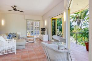 a living room with a couch and chairs at The Hill Villa 2 in Port Douglas