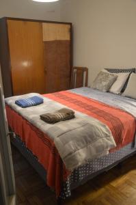 a bedroom with a bed with an orange blanket at Habitación "Norte" con baño privado al fondo de la casa in Salto +6 photos