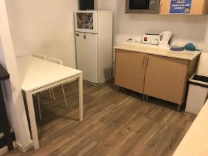 a small kitchen with a table and a refrigerator at Majestic Hostel Porto in Porto