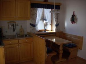 a kitchen with wooden cabinets and a sink and a window at Haus Hinterseer in Schneizlreuth