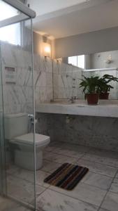 une salle de bain avec toilettes, lavabo et miroir dans l'établissement Hostel Triplo J e Guest House, à Salvador 30 autres photos