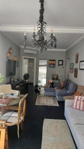 un salon avec des canapés et un lustre dans l'établissement Hostel Triplo J e Guest House, à Salvador